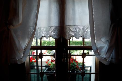 a window with a white curtain and a flower pot at Boutique Hotel Musée in Gjirokastër