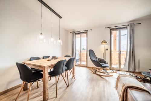 une salle à manger avec une table et des chaises en bois dans l'établissement Apartment Redwood Alpe D'Huez - by EMERALD STAY, à Huez