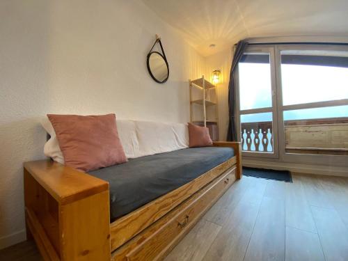 - un canapé dans une chambre avec une grande fenêtre dans l'établissement Studio pour 4 personnes avec balcon, à 2 pas des pistes et commerces, cœur de station, Modane - FR-1-265-224, à Valfréjus