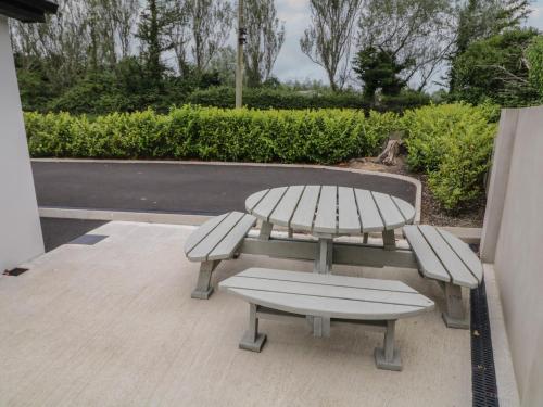 a picnic table and two benches on a patio at Mountain View in Limavady