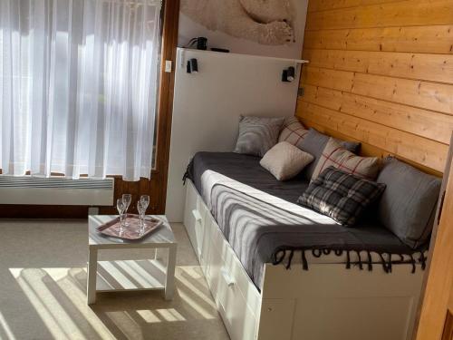 - un petit lit dans une chambre avec une table dans l'établissement Studio rénové à Morzine, proche centre, balcon, bien équipé, pour 4 pers., navettes gratuites - FR-1-524-66, à Morzine
