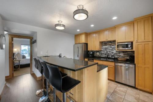 a kitchen with wooden cabinets and a black counter top at Ski Vista Chic Condo Near the Canyons Slopes in Park City