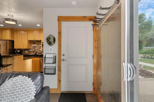 a living room with a white door and a kitchen at Ski Vista Chic Condo Near the Canyons Slopes in Park City