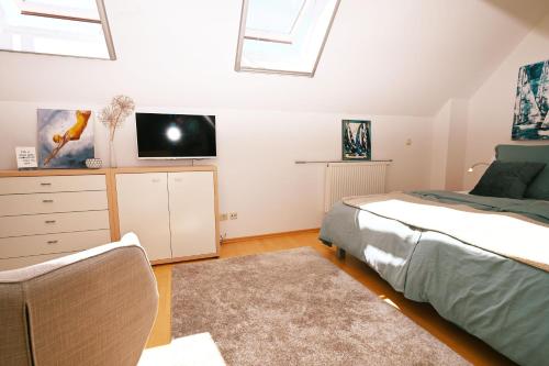 a bedroom with a bed and a tv on the wall at Kunst küsst Küste in Hohwacht