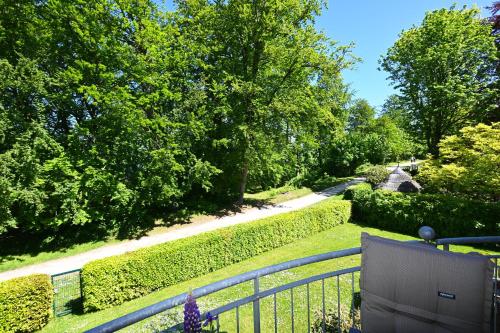 a garden with a fence and bushes and trees at Kunst küsst Küste in Hohwacht