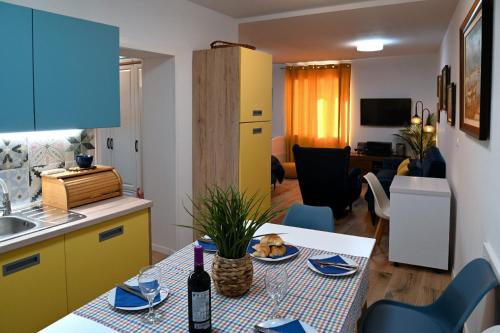 a kitchen and living room with a table with a bottle of wine at Studio Apartman Ivan in Novigrad Dalmatia
