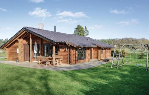 a log cabin with a picnic table and a playground at Holiday Home Lyngbjergvej Vi in Fjerritslev
