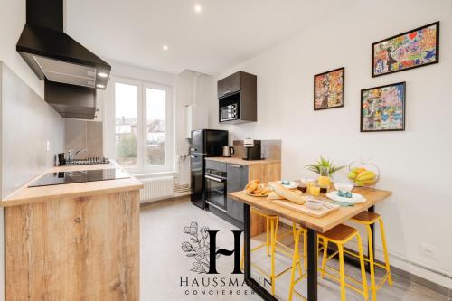 une cuisine avec une table en bois et des tabourets de bar jaunes dans l'établissement Magnifique Appartement Pop Art Nancy, à Nancy