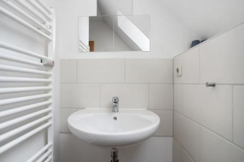 a white bathroom with a sink and a mirror at Abendsonne in Ostseebad Koserow