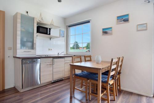 a kitchen with a table and chairs in a room at Abendsonne in Ostseebad Koserow