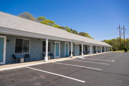 an empty parking lot in front of a building at Endless Dunes, A Modern Motel in Eastham