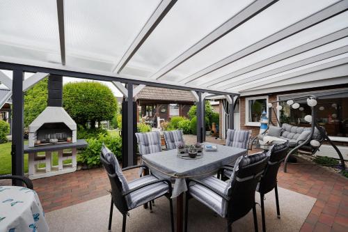 a patio with a table and chairs and a fireplace at Ferienwohnung Heimathafen in Lensahn