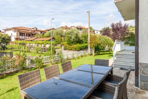a patio with a table and chairs in a yard at Villa La Lanterna Bianca a Bagnone in Bagnone