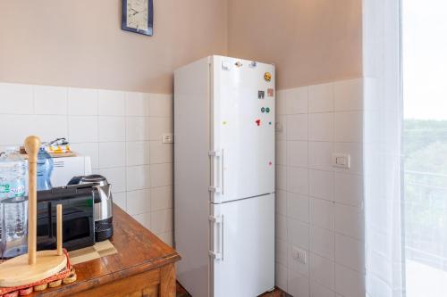 a white refrigerator in a kitchen next to a microwave at Villa La Lanterna Bianca a Bagnone in Bagnone