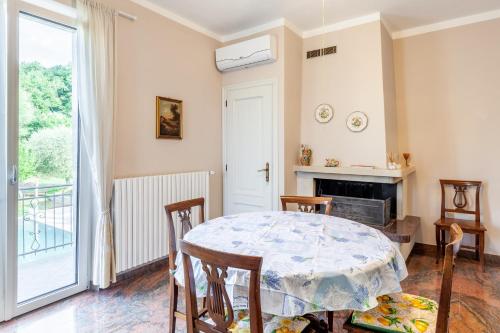 a dining room with a table and chairs and a fireplace at Villa La Lanterna Bianca a Bagnone in Bagnone