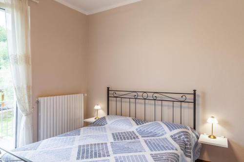 a bedroom with a bed and two lamps and a window at Villa La Lanterna Bianca a Bagnone in Bagnone