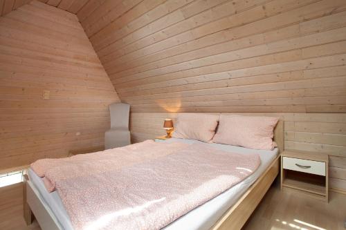 a bedroom with a bed in a wooden wall at Ferienwohnungen Roth in Willingen