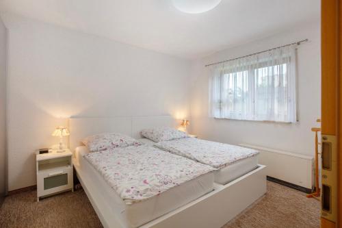 a white bedroom with a bed and a window at Ferienwohnung Brockmann in Waldshut-Tiengen