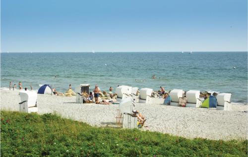 a group of people on a beach with chairs and the ocean at Strandblick 36 in Schönhagen