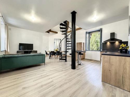 un grand salon avec un canapé vert et un escalier dans l'établissement Charmant Duplex au Cœur Vosgien, à Charmes