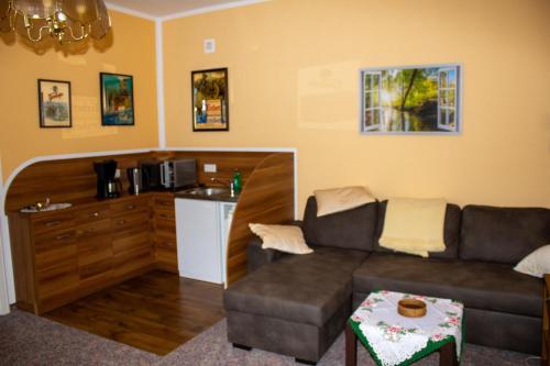 a living room with a couch and a kitchen at Damwildhof Fewo zur Linde in Blievenstorf