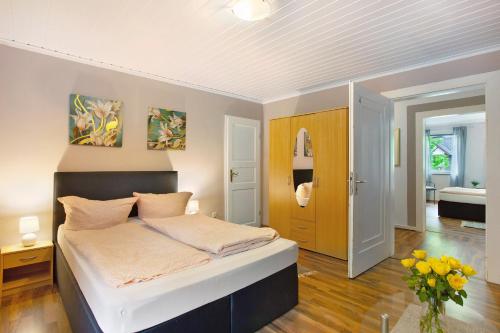 a bedroom with a bed and a vase of yellow flowers at Ferienwohnungen Roth in Willingen