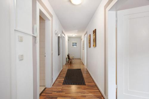a hallway with white walls and wooden floors at Ferienwohnungen Roth in Willingen