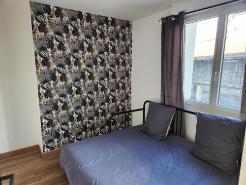 - une chambre avec un mur orné d'un papier peint à oiseaux dans l'établissement T3 Cosy, à Saint-Étienne