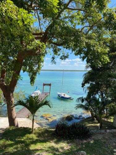 a boat in the water next to a beach at Casa Piedra de Agua Bacalar in Bacalar
