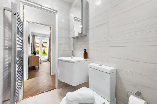 a white bathroom with a toilet and a sink at Stylish 4 bedroom I extended stays I contractors in Harrow