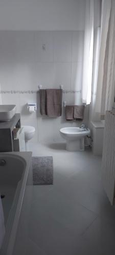 a white bathroom with a sink and a toilet at La Curta di Vegèss in Pregnana Milanese