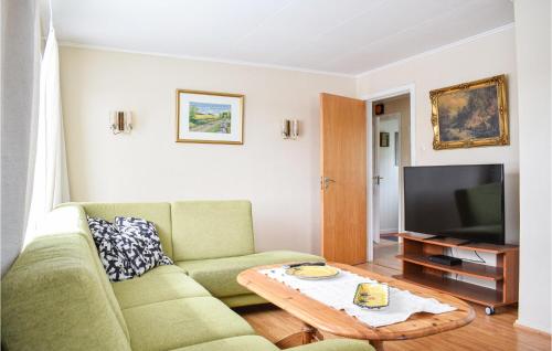 a living room with a green couch and a coffee table at Stunning Home In Seim With Wifi in Seim