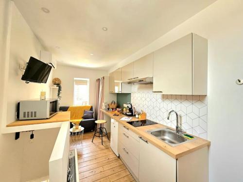 une cuisine avec un évier et un plan de travail dans l'établissement le nido -studette - clim - coeur de ville, à Nîmes