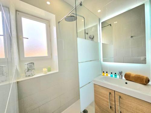 une salle de bain avec une douche, un lavabo et un miroir dans l'établissement le nido -studette - clim - coeur de ville, à Nîmes