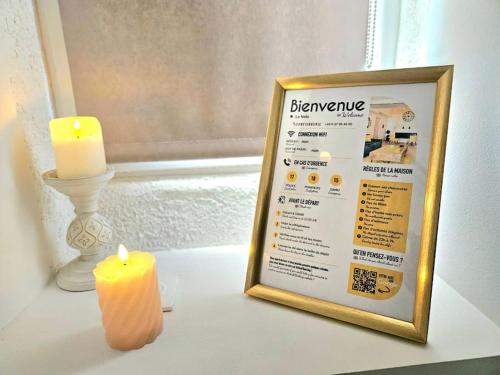 une bougie et un panneau sur une table à côté d'une fenêtre dans l'établissement le nido -studette - clim - coeur de ville, à Nîmes