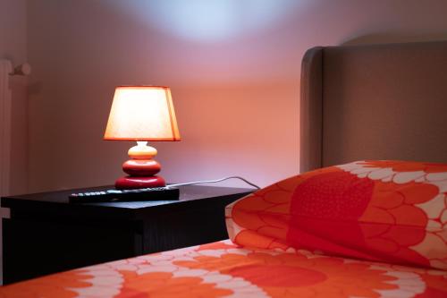 a lamp sitting on a table next to a bed at Sunshine Apartment - Salerno in Salerno
