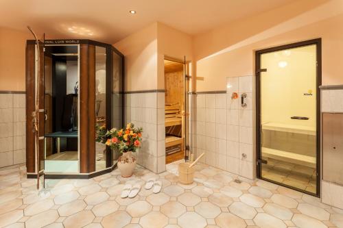 a large bathroom with a shower and a toilet at Hotel Garni Hanslerhof " Urlaub am Bauernhof " in Gerlos