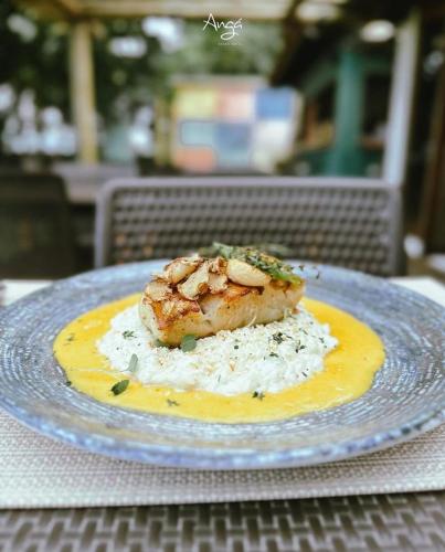 a plate with a piece of food on top of rice at Angá Beach Hotel in São Miguel dos Milagres