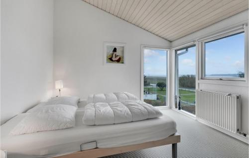 a white bedroom with a bed and a large window at Stunning Home In Randers Nø With Wifi in Skalmstrup