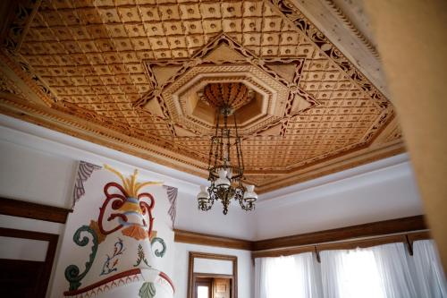 a coffered ceiling with a chandelier in a room at Boutique Hotel Musée in Gjirokastër