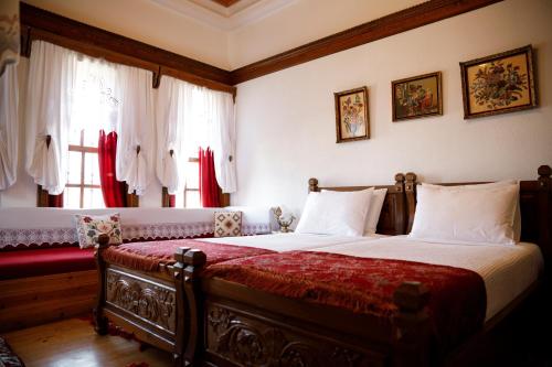 a bedroom with a large bed with a red blanket at Boutique Hotel Musée in Gjirokastër