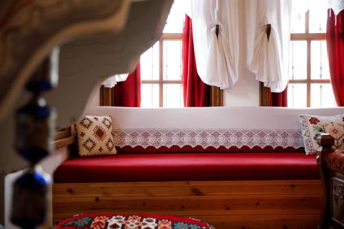 a red bench sitting in front of a window at Boutique Hotel Musée in Gjirokastër