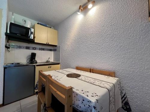 Il comprend une petite cuisine avec une table et une petite cuisine avec une cuisinière. dans l'établissement Charmant studio aux Molanès, Uvernet-Fours, idéal pour les skieurs, très confortable pour 2 personnes - FR-1-165A-173, à Uvernet