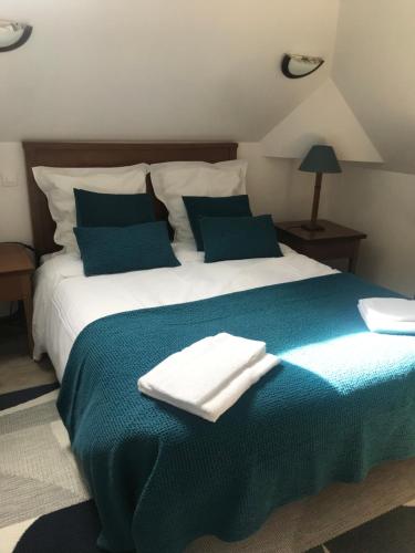 伊利耶Hotel de l image的一张配有蓝色和白色床单及枕头的大床