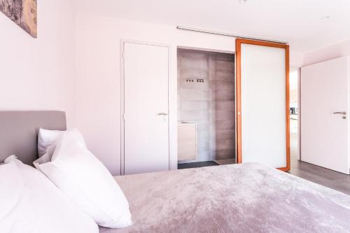 a bedroom with white walls and a bed with white pillows at Domaine Saint Thomas in Argelès-sur-Mer