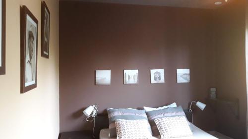 - une chambre dotée d'un lit avec des photos sur le mur dans l'établissement Villa Serendip proche du lac, à Lacanau