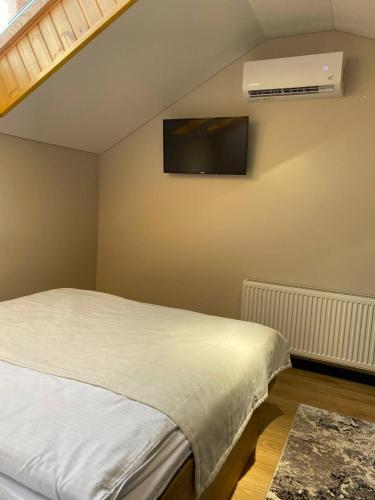 a bedroom with a bed and a tv on the wall at Discovery Garden apartments in Khmelʼnytsʼkyy
