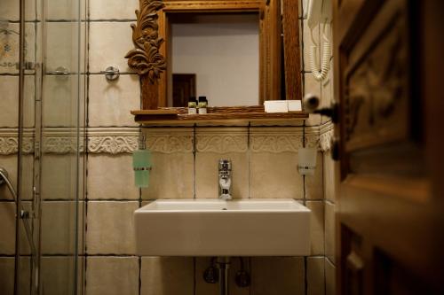 a white sink in a bathroom with a mirror at Boutique Hotel Musée in Gjirokastër