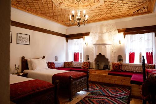 a bedroom with two beds and a chandelier at Boutique Hotel Musée in Gjirokastër