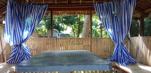 a table with blue curtains on a wooden fence at Roundhouse Sipalay in Lagob